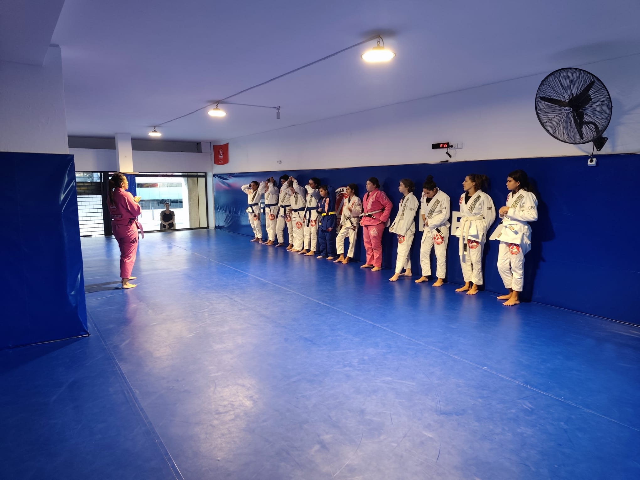 Turma de Jiu-Jitsu na Gracie Barra Braga, alunas alinhadas junto à parede durante o treino