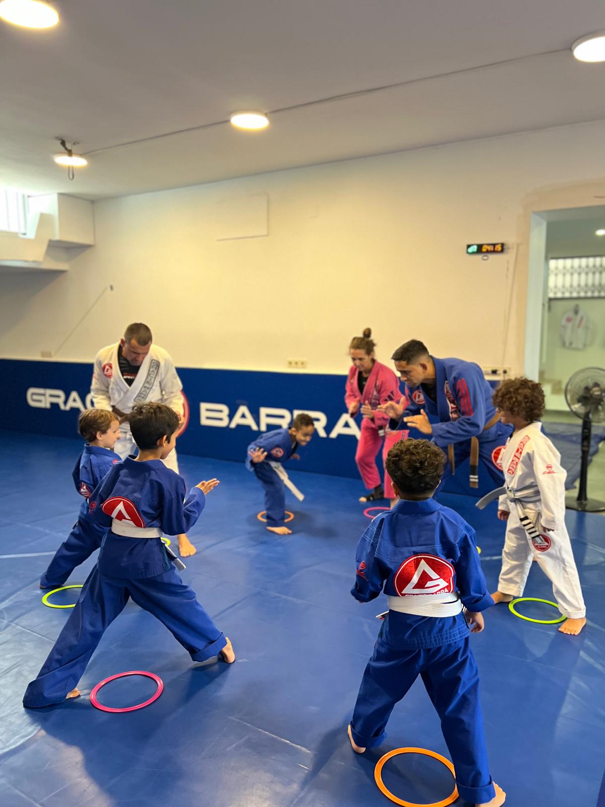 Crianças em treino de jiu-jitsu na Gracie Barra Braga, em roda com os instrutores